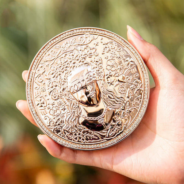Hand holding the Goddess Of Luck Eye Shadow Palette featuring a decorative golden design.