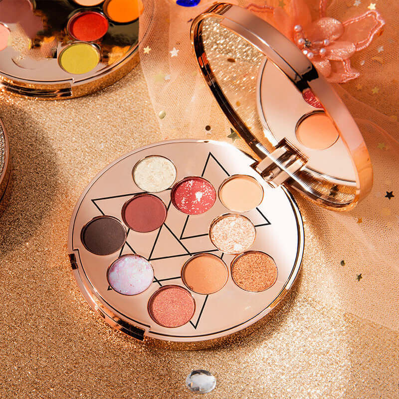 Goddess of Luck 10-color waterproof eyeshadow palette showcasing vibrant shades on a sparkly backdrop.