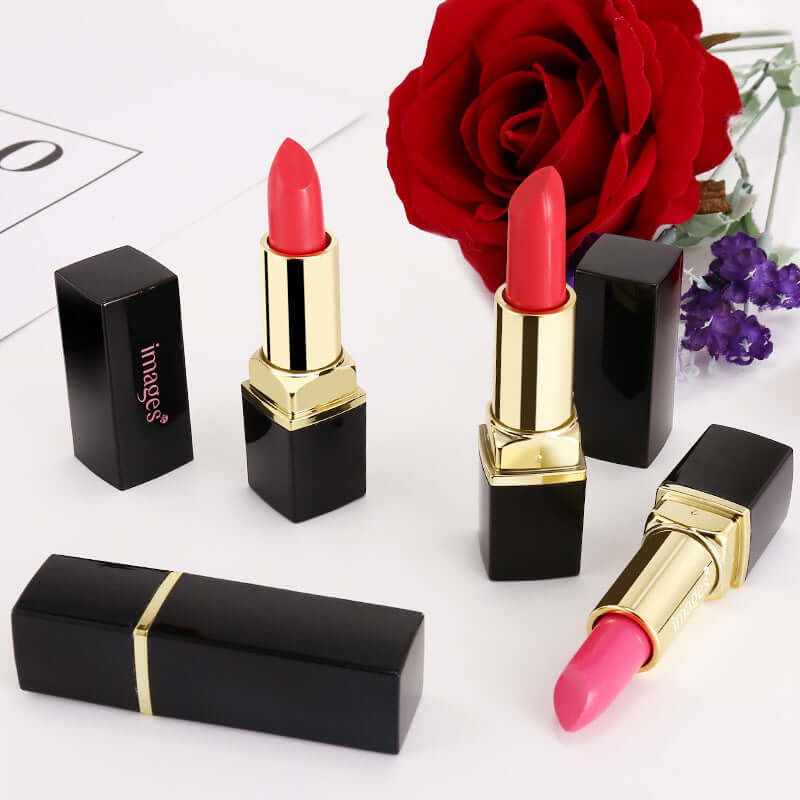 Three vibrant lipsticks in black cases, next to a red rose and purple flowers, showcasing moisturizing lip gloss options.