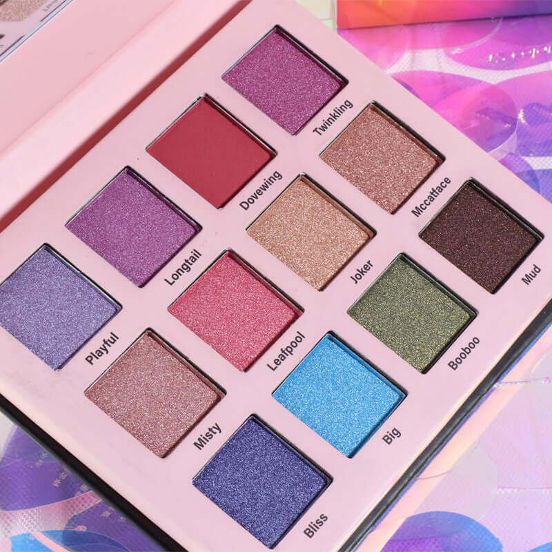 Fashion Creative 12 Color Eye Shadow Palette showcasing vibrant shades like Playful, Twinkling, and Mud on a pink background.