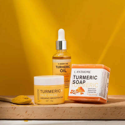Lanthome turmeric skin care set including turmeric oil, cream, and soap on a wooden surface with a yellow background.