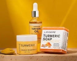 Ginger Butter Skin Care Set featuring turmeric soap, turmeric oil, and turmeric face cream on a bright yellow background.