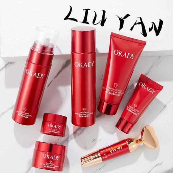 High-end skin care product set in red packaging including lotion, cleanser, and creams on a marble surface.