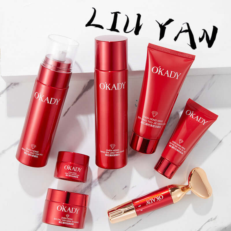 High-end skin care product set in red packaging including lotion, cleanser, and creams on a marble surface.