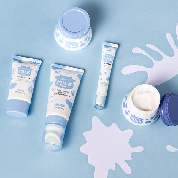 Five-piece Milk Skin Care set including moisturizing cream, sunscreen, and eye cream on a colorful background.