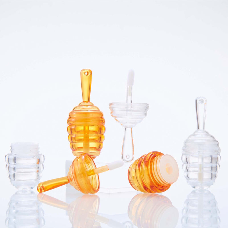 Mini Bee Fang honeycomb lip gloss tubes in clear and orange colors, perfect for stylish lipstick packaging and applications.