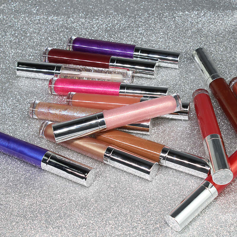 Variety of pearl lip gloss tubes in a rainbow of colors on a sparkling silver background.