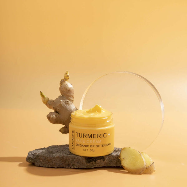 Turmeric Essential Oil Face Cream in a yellow jar on a stone display, designed to brighten and nourish skin.