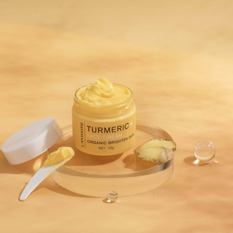 Turmeric face cream in jar on golden background, showcasing organic ingredients for brightening skin.